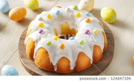 Festive spring dessert with colorful icing and candy adorned around a beautifully baked cake on a wooden platter during an Easter celebration 124847104