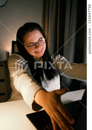 Cheerful millennial woman enjoy videocall with friends using laptop. Gesturing and smiling. Talking with friends who living far. Cherishing long distance friendship. 124847798