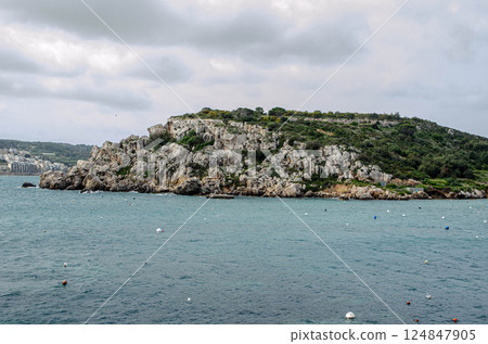 Rocky Coastal Island Under Cloudy Sky Rocky Coastal Island Under Cloudy Sky 124847905