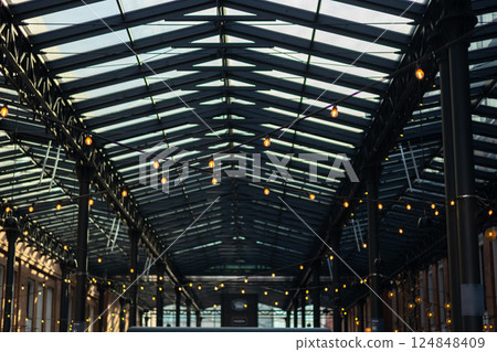 Garlands of lamps on the street. Light bulb decor, the string of lights on a urban background Garlands of lamps on the street. Light bulb decor, the string of lights on a urban background 124848409