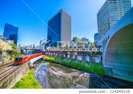 New view of Tokyo cityscape in Japan. Marunouchi Line 2000 series, Ochanomizu Station, Hijiri Bridge. Flower rafts spread out on the water. 124849139