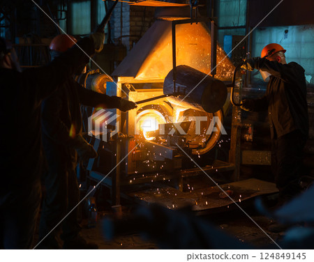Pouring molten metal into a centrifugal machine in the foundry shop of metallurgical plant 124849145