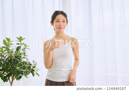 Woman drinking water in a glass Woman drinking water in a glass 124849187