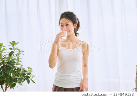 在玻璃的婦女飲用水 在玻璃的婦女飲用水 124849188