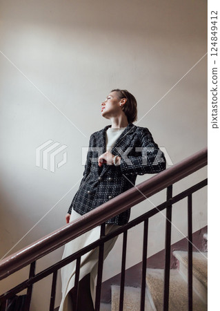 Woman in dress and business jacket climbing stairs 124849412