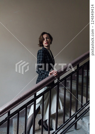 Woman in dress and business jacket climbing stairs 124849414