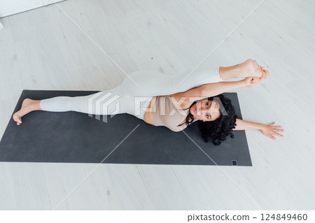 woman doing asana gymnastics on the floor in the hall 124849460