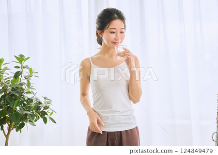 Woman drinking water in a glass 124849479