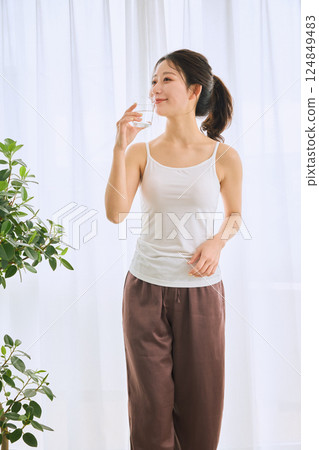 Woman drinking water in a glass 124849483