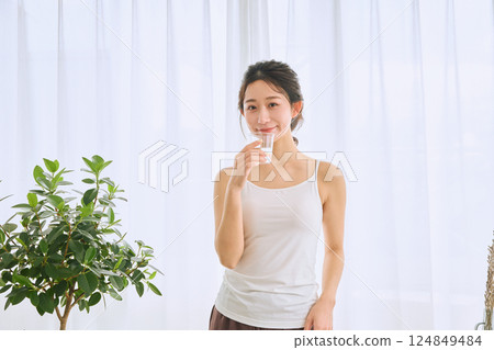 在玻璃的婦女飲用水 124849484