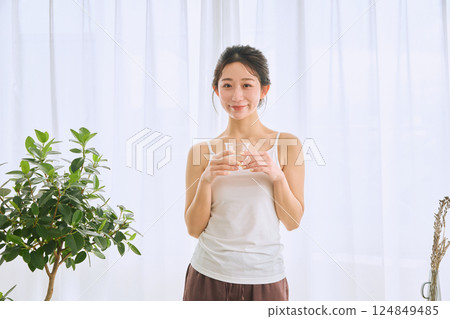在玻璃的婦女飲用水 124849485