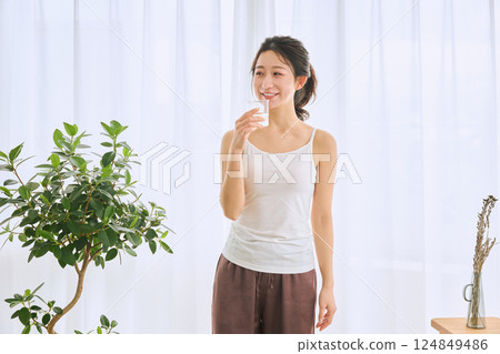 Woman drinking water in a glass Woman drinking water in a glass 124849486