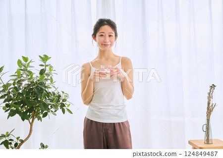 Woman drinking water in a glass Woman drinking water in a glass 124849487