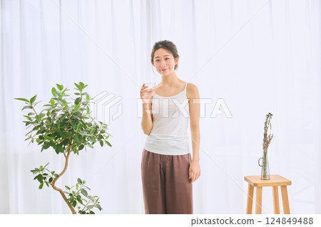 Woman drinking water in a glass 124849488