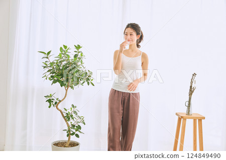 在玻璃的婦女飲用水 124849490
