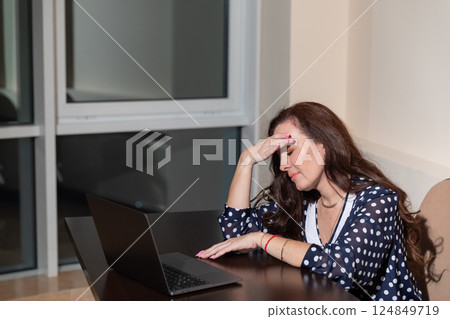 Woman working on laptop at desk 124849719