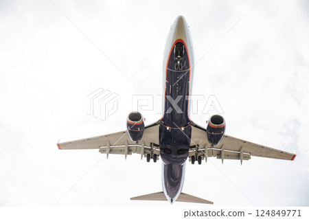 A passenger plane flying in the clouds in the sky A passenger plane flying in the clouds in the sky 124849771