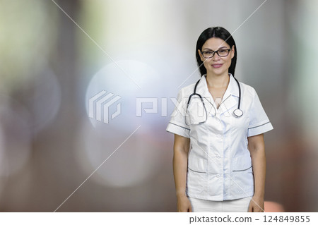 Porrait of a young asian female doctor wearing glasses and stethoscope. Abstract blurred background. 124849855