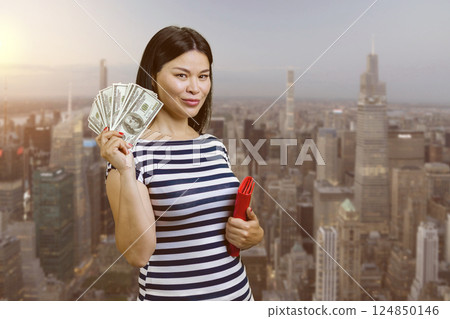 Young korean woman with fan of money from a red wallet. Urban cityscape background. Young korean woman with fan of money from a red wallet. Urban cityscape background. 124850146