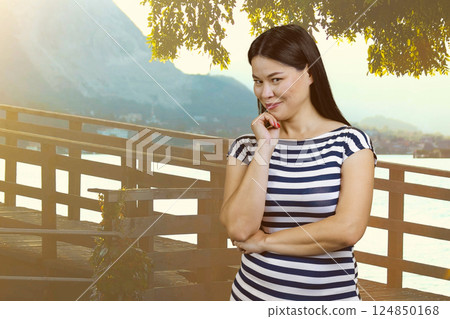Portrait of attractive brunette asian woman on vacation. Glance at you. Summer resort background. 124850168
