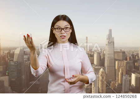 Portrait of asian female boss is scolding you for something outdoors. Urban cityscape background. 124850268