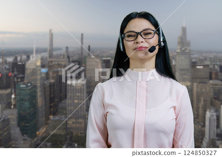 Young asian female customer support representative wearing headset. Urban cityscape background. Young asian female customer support representative wearing headset. Urban cityscape background. 124850327