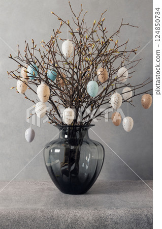 Easter tree decorated colorful pastel white and beige eggs. Birch branches with hang eggs in vase on gray background. Vertical format. Happy Easter greeting card. 124850784