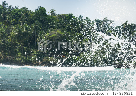 Tropical beach with palms tree and clear blue ocean splash for surf. Summer landscape, travel concept. Inside wave. Tropical beach with palms tree and clear blue ocean splash for surf. Summer landscape, travel concept. Inside wave. 124850831