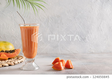Asian traditional Papaya lassi on light gray background. Freshness cold beverage made of yogurt, water, spices, fruits and ice. Popular beverage in India and Sri Lanka. Copy space 124850845