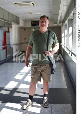 An Adult Man in a Green T-Shirt and Shorts Stands Confidently in a Subway Passage, Capturing the Everyday Life and Unique Style of Urban Commuters in a Bustling Metro Environment An Adult Man in a Green T-Shirt and Shorts Stands Confidently in a Subway Passage, Capturing the Everyday Life and Unique Style of Urban Commuters in a Bustling Metro Environment 124850942