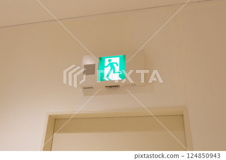 Emergency exit guide light in the facility: A pictogram of a green person running Emergency exit guide light in the facility: A pictogram of a green person running 124850943