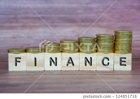 Finance text on wooden cubes with coins stacking on top Finance text on wooden cubes with coins stacking on top 124851718
