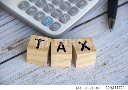 Top view of Tax Time text on wooden cubes with calculator background 124851721