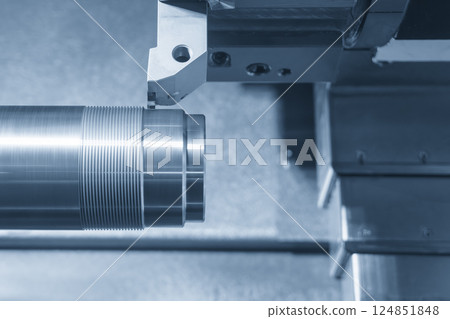 Close up scene the CNC lathe machine groove cutting the metal shaft parts in the light blue scene. Close up scene the CNC lathe machine groove cutting the metal shaft parts in the light blue scene. 124851848