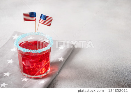 Patriotic red pomegranate margarita cocktail on blue background. Rim your festive beverages in blue sugar for popping for July 4th. Close up. Copy space. 124852011