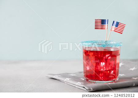 Patriotic red pomegranate margarita cocktail on blue background. Rim your festive beverages in blue sugar for popping for July 4th. Close up. Copy space. 124852012
