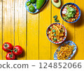 Delicious selection of traditional Mexican dishes showcasing fried tortilla, Aztec soup, and fresh ingredients for a festive celebration 124852066