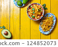 Delicious tortilla fried Aztec soup served with fresh avocado and lime on a vibrant yellow table 124852073
