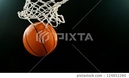 Detail of basketball ball hitting the hoop, top view. Isolated on black background. 124852260