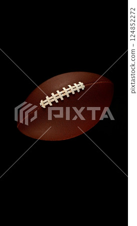 Detail of american football ball isolated on black background. 124852272