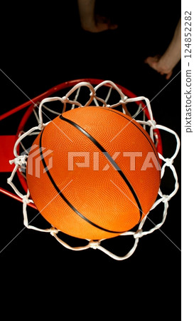 Detail of basketball ball hitting the basket, top view. Isolated on black background. 124852282
