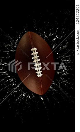 Detail of american football ball with splashing water. Isolated on black background. Detail of american football ball with splashing water. Isolated on black background. 124852291
