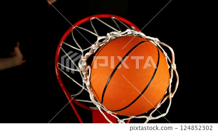 Detail of basketball ball hitting the basket, top view. Isolated on black background. Detail of basketball ball hitting the basket, top view. Isolated on black background. 124852302