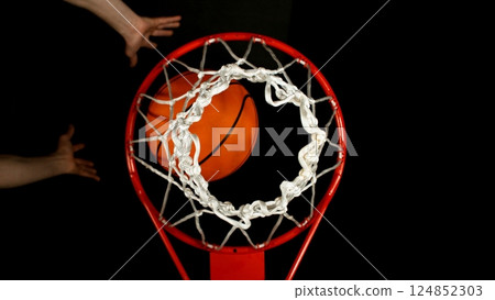 Detail of basketball ball hitting the basket, top view. Isolated on black background. Detail of basketball ball hitting the basket, top view. Isolated on black background. 124852303