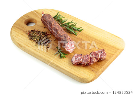 Sliced dry cured sausage on a cutting board. 124853524