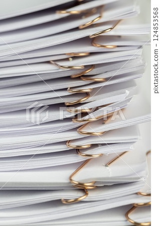 joined white sheets of cellulose paper for records, stapled together white paper for documentation, side view joined white sheets of cellulose paper for records, stapled together white paper for documentation, side view 124853568