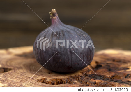 one purple figs on a juniper board, ripe fig fruit on the kitchen table before cooking 124853623