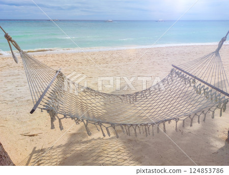 Relaxing hammock on sandy beach with turquoise water in tropical paradise 124853786