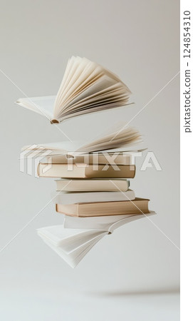 Open and closed books are levitating on a plain background, creating a visually appealing composition that promotes the joy of reading and literature 124854310