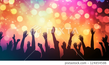 Silhouetted audience members raising hands and cheering joyfully during a vibrant live music festival, surrounded by colorful lights and an electric atmosphere of celebration and excitement 124854586
